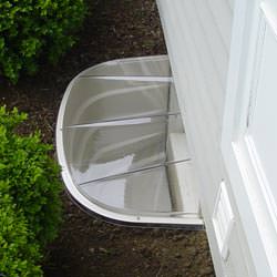 A vinyl basement window and covered window well in Clarkston