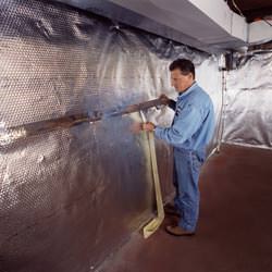 Installation of a radiant heat and vapor barrier on a basement wall in Roseville